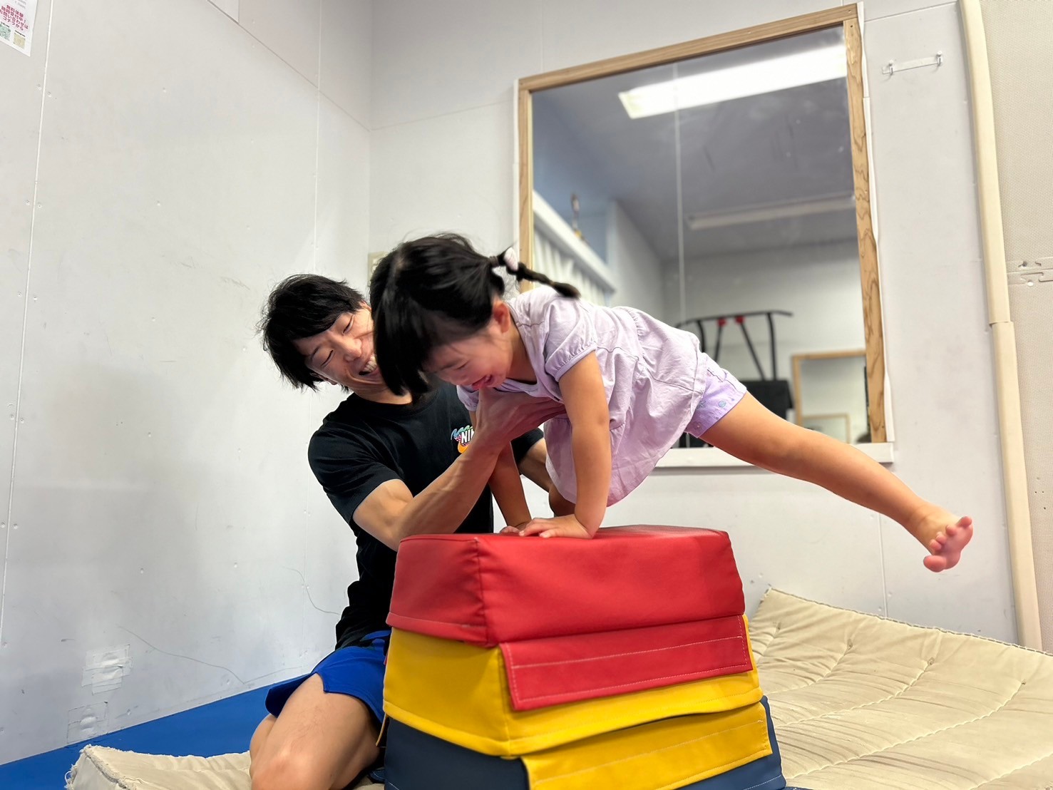 跳び箱の練習をする女の子とコーチ